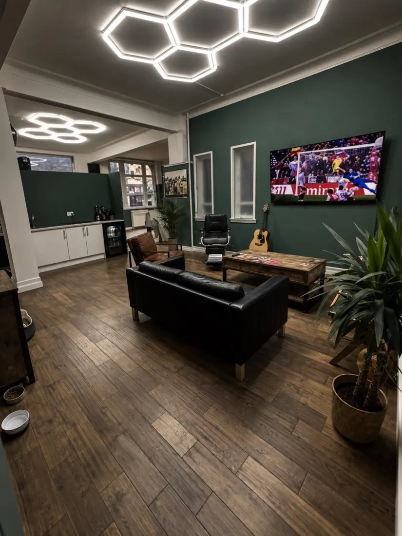 Waiting area with a leather sofa, the telly on and Sally&rsquo;s bowls by the wall